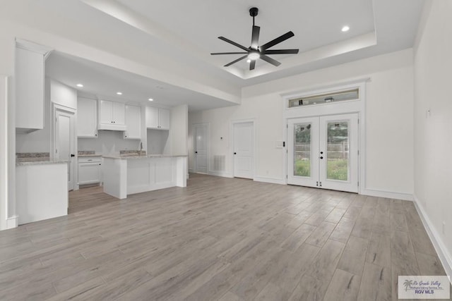 1838 Castillo St, Olmito, TX 78575 - unfurnished living room featuring a raised ceiling, light wood-type flooring, a ceiling fan, french doors, and recessed lighting