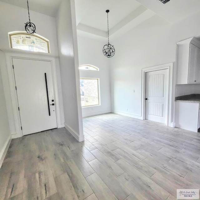 foyer with a chandelier, a high ceiling, and light hardwood / wood-style flooring