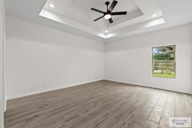 1838 Castillo St, Olmito, TX 78575 - spare room with a tray ceiling, wood finished floors, recessed lighting, and ceiling fan