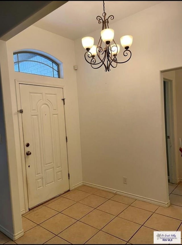 foyer with light tile patterned floors and a notable chandelier