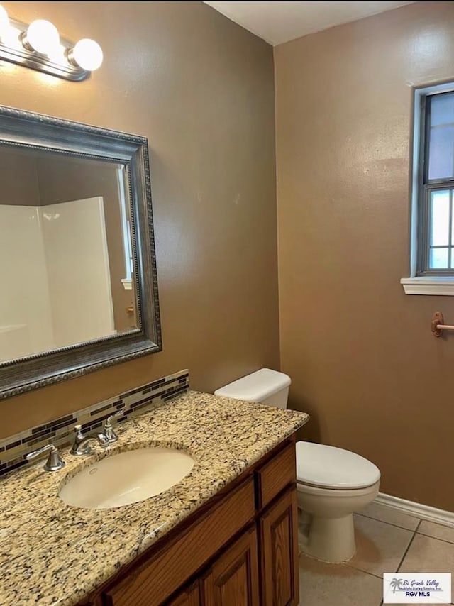 bathroom featuring tile patterned flooring, vanity, and toilet