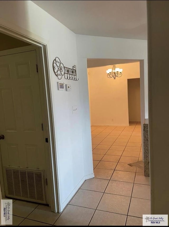 hall featuring a chandelier and light tile patterned floors