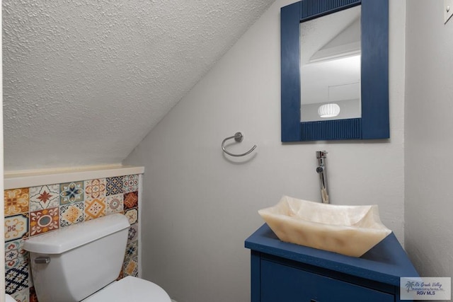 bathroom with vanity, toilet, and a textured ceiling