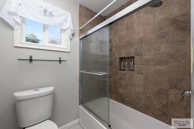 bathroom featuring shower / bath combination with glass door and toilet