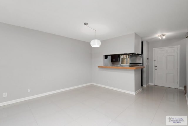 kitchen with tile patterned floors, decorative light fixtures, stainless steel fridge, and kitchen peninsula