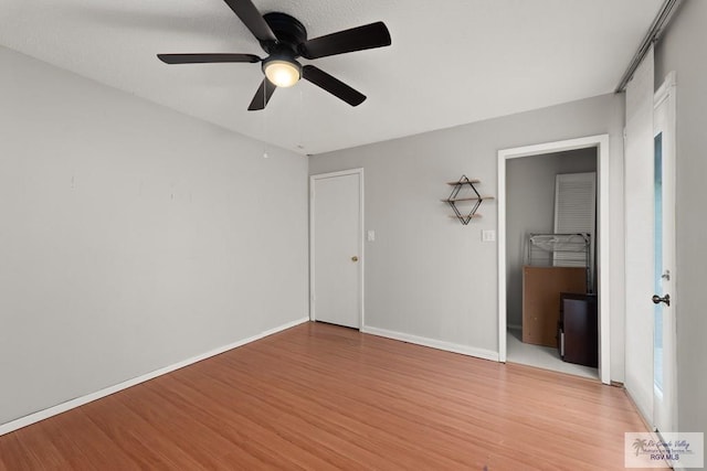 unfurnished bedroom featuring ceiling fan, a closet, and light hardwood / wood-style flooring