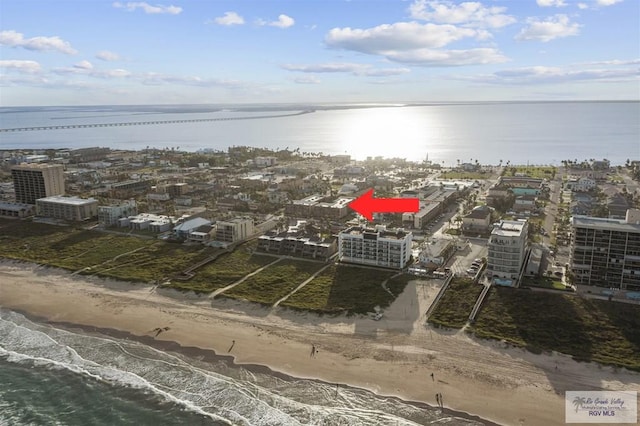 drone / aerial view featuring a water view and a view of the beach