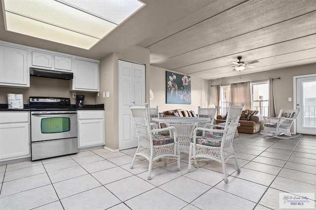 kitchen featuring light tile patterned floors, white cabinetry, and stainless steel electric range