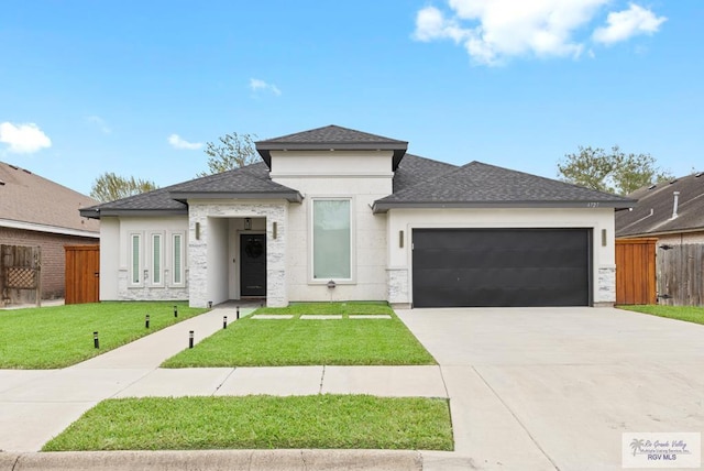 prairie-style house featuring a garage and a front lawn