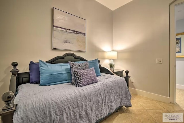 tiled bedroom featuring vaulted ceiling