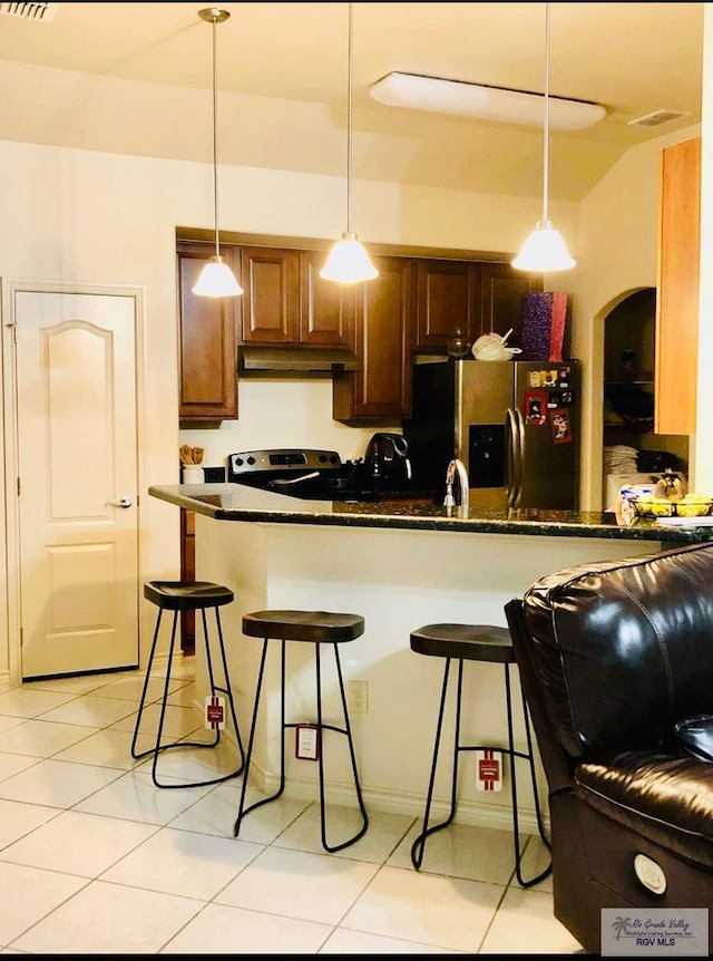 kitchen with appliances with stainless steel finishes, decorative light fixtures, a kitchen breakfast bar, and kitchen peninsula