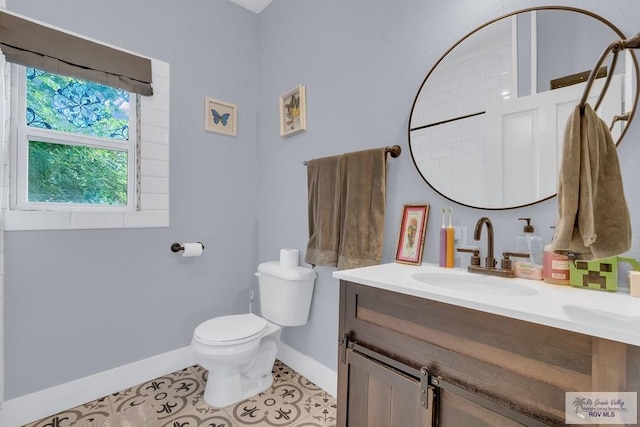 bathroom with tile patterned flooring, vanity, and toilet