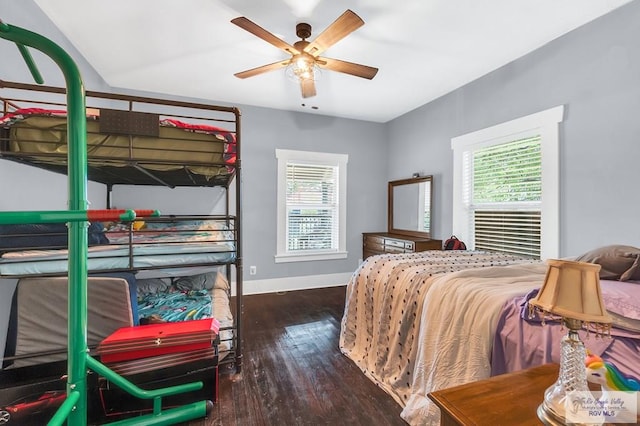 bedroom featuring multiple windows, dark wood-type flooring, and ceiling fan