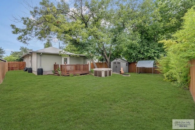 view of yard featuring a storage unit and a deck