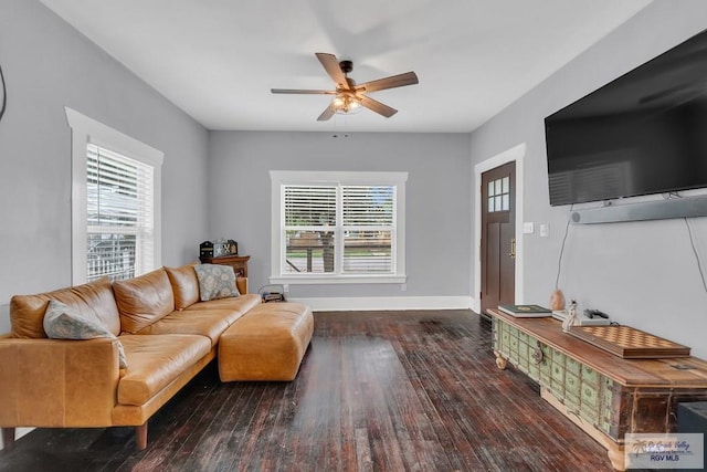 living room with ceiling fan, plenty of natural light, and dark wood-type flooring