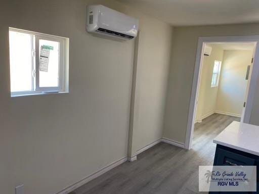 interior space featuring a healthy amount of sunlight, an AC wall unit, and light hardwood / wood-style flooring