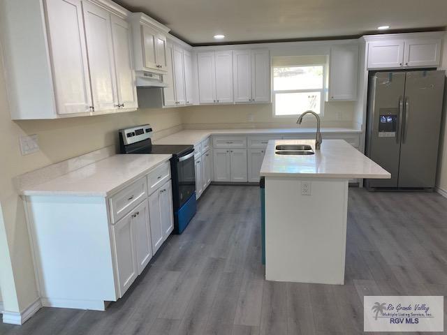 kitchen with a kitchen island with sink, sink, white cabinets, and stainless steel appliances