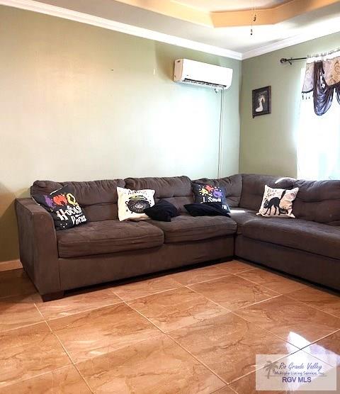 living room with a raised ceiling, a wall mounted AC, crown molding, and ceiling fan