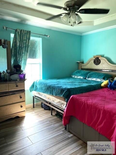 bedroom with ceiling fan, crown molding, and hardwood / wood-style flooring