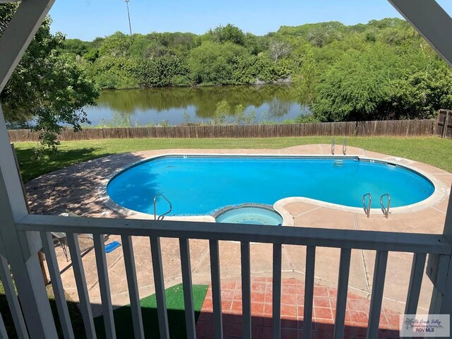 view of pool featuring an in ground hot tub, a patio area, and a water view