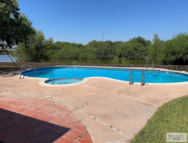 200 E Resaca Dr, Los Fresnos, TX 78566 - view of swimming pool featuring a patio, a pool with connected hot tub, and a wooded view