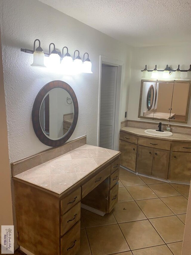 bathroom featuring a textured ceiling, tile patterned floors, and vanity