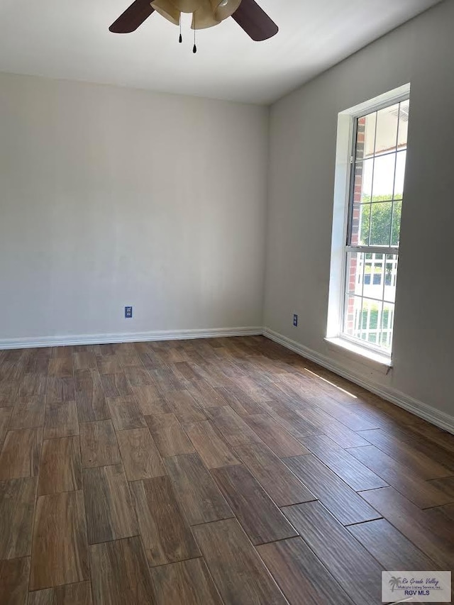 spare room featuring ceiling fan and dark wood-type flooring