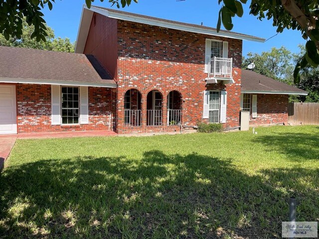 back of house with a garage and a yard