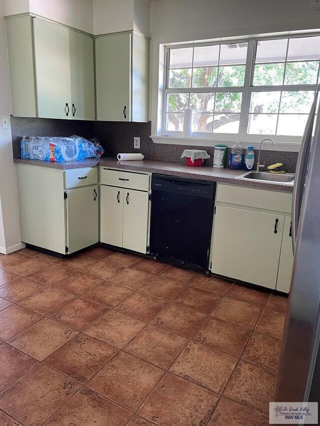 kitchen with dishwasher, sink, white cabinets, tasteful backsplash, and stainless steel refrigerator