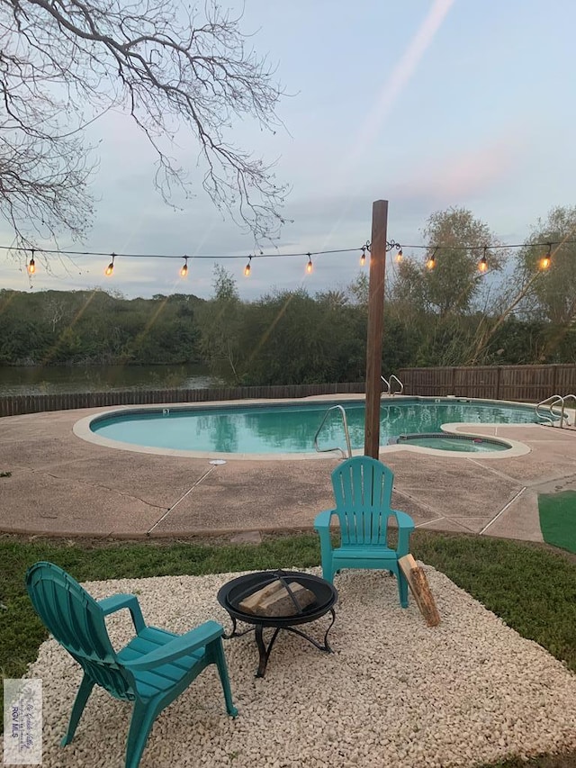 view of swimming pool featuring an outdoor fire pit, a patio area, and a hot tub