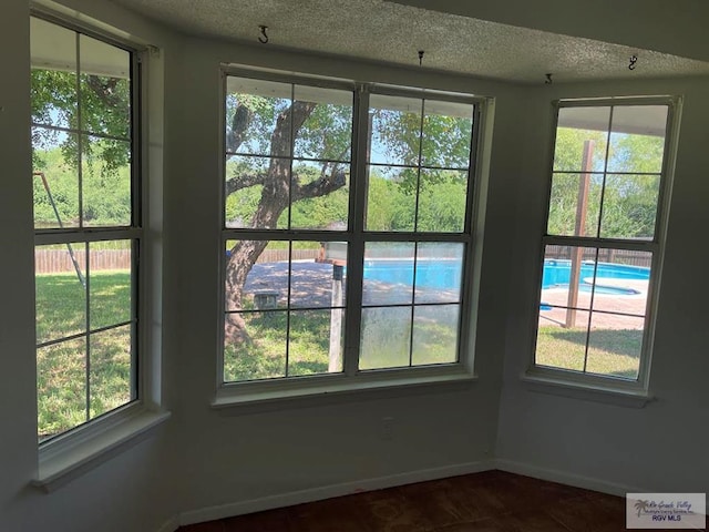 200 E Resaca Dr, Los Fresnos, TX 78566 - unfurnished dining area with plenty of natural light, a textured ceiling, and dark tile patterned floors