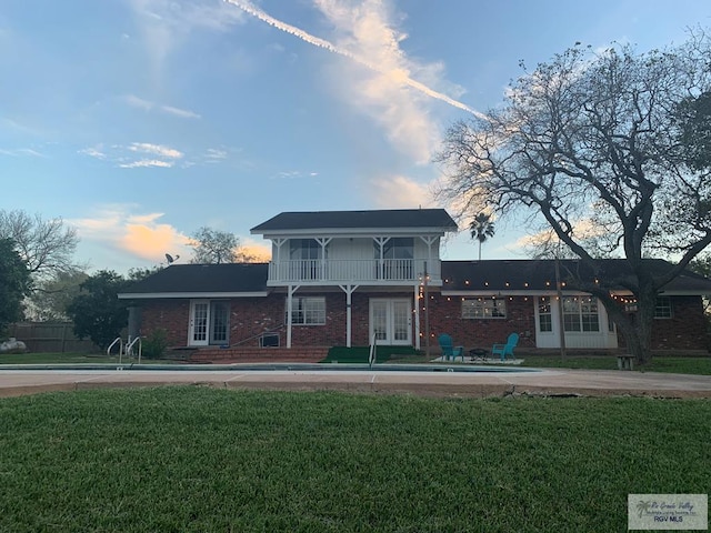 200 E Resaca Dr, Los Fresnos, TX 78566 - traditional-style home with french doors, a balcony, brick siding, and a patio area