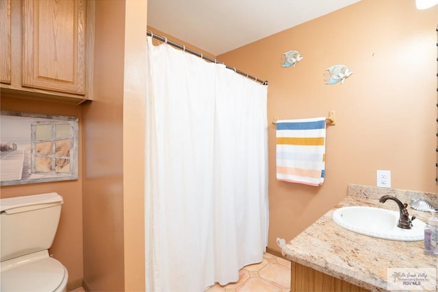 bathroom with tile patterned flooring, vanity, and toilet