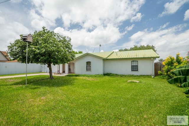 rear view of house featuring a lawn