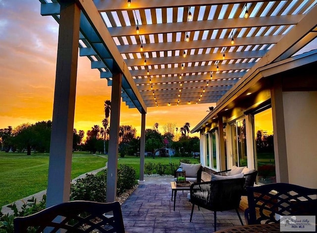 patio terrace at dusk featuring an outdoor living space, a pergola, and a yard