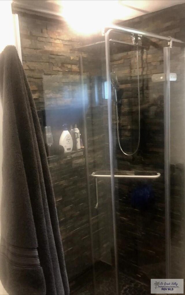 bathroom featuring a shower with door