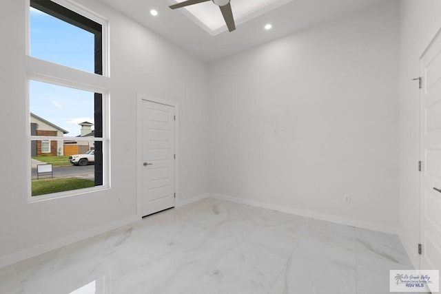 unfurnished room with a towering ceiling and ceiling fan