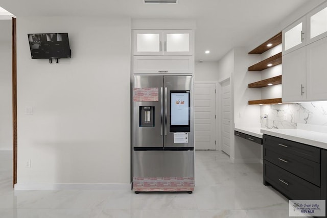 kitchen featuring white cabinetry, stainless steel refrigerator with ice dispenser, and tasteful backsplash