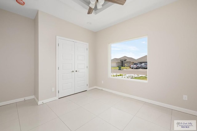 unfurnished bedroom featuring ceiling fan, a closet, and light tile patterned floors