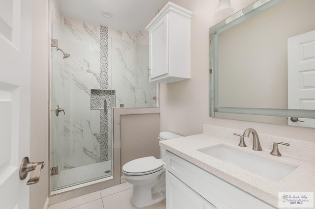 bathroom featuring tile patterned flooring, vanity, an enclosed shower, and toilet