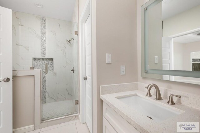 bathroom featuring tile patterned flooring, vanity, and a shower with shower door