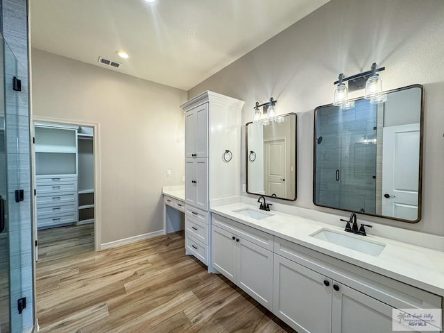 bathroom featuring vanity, hardwood / wood-style flooring, and walk in shower