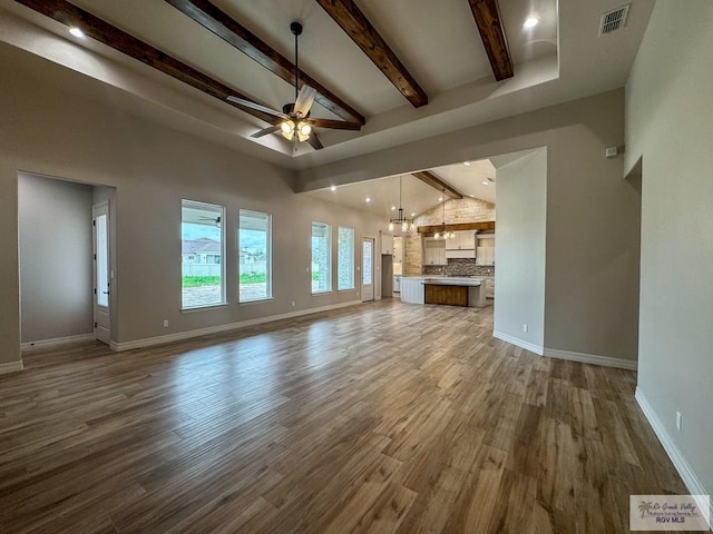 unfurnished living room with beam ceiling, high vaulted ceiling, ceiling fan, and wood-type flooring