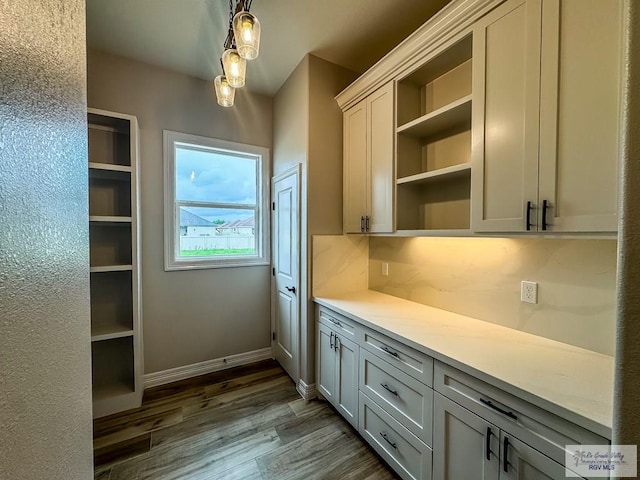 interior space featuring pendant lighting, dark hardwood / wood-style flooring, gray cabinets, and backsplash