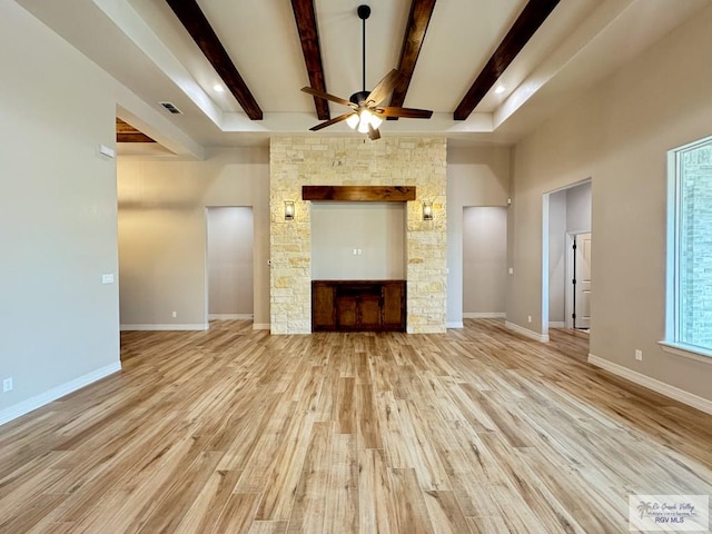 unfurnished living room featuring beamed ceiling, light wood-type flooring, and ceiling fan