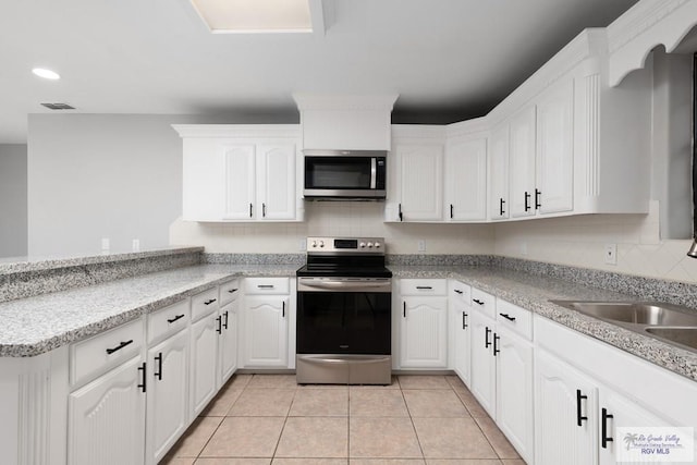 kitchen with white cabinets, visible vents, stainless steel appliances, and backsplash