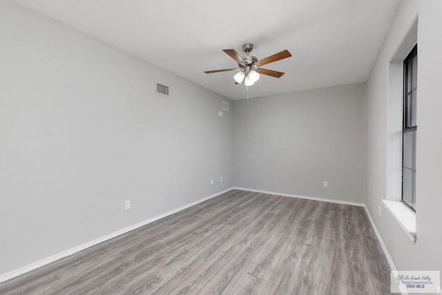 empty room with a ceiling fan, light wood-style flooring, visible vents, and baseboards