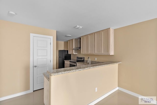 kitchen featuring black refrigerator, electric range, kitchen peninsula, wall chimney exhaust hood, and light brown cabinets