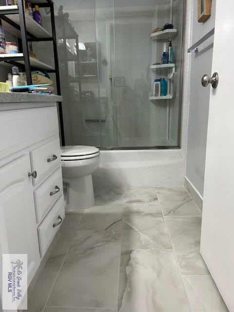 bathroom with vanity, a shower with shower door, and toilet