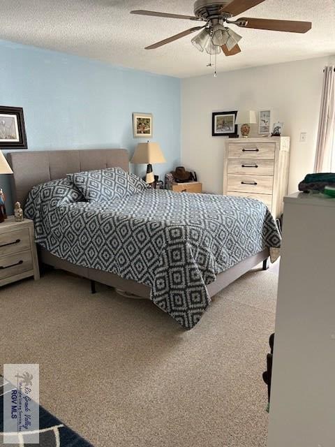 bedroom with ceiling fan, carpet flooring, and a textured ceiling